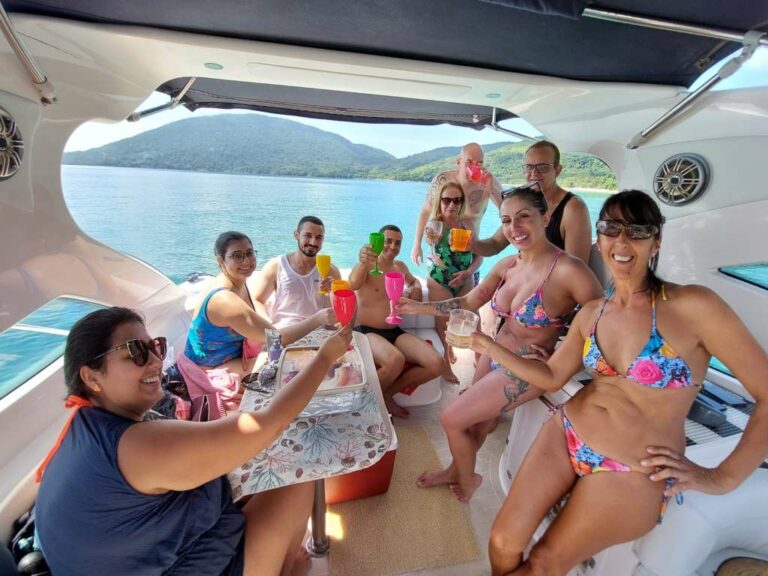 Pessoas segurando taças e confraternizando dentro da lancha